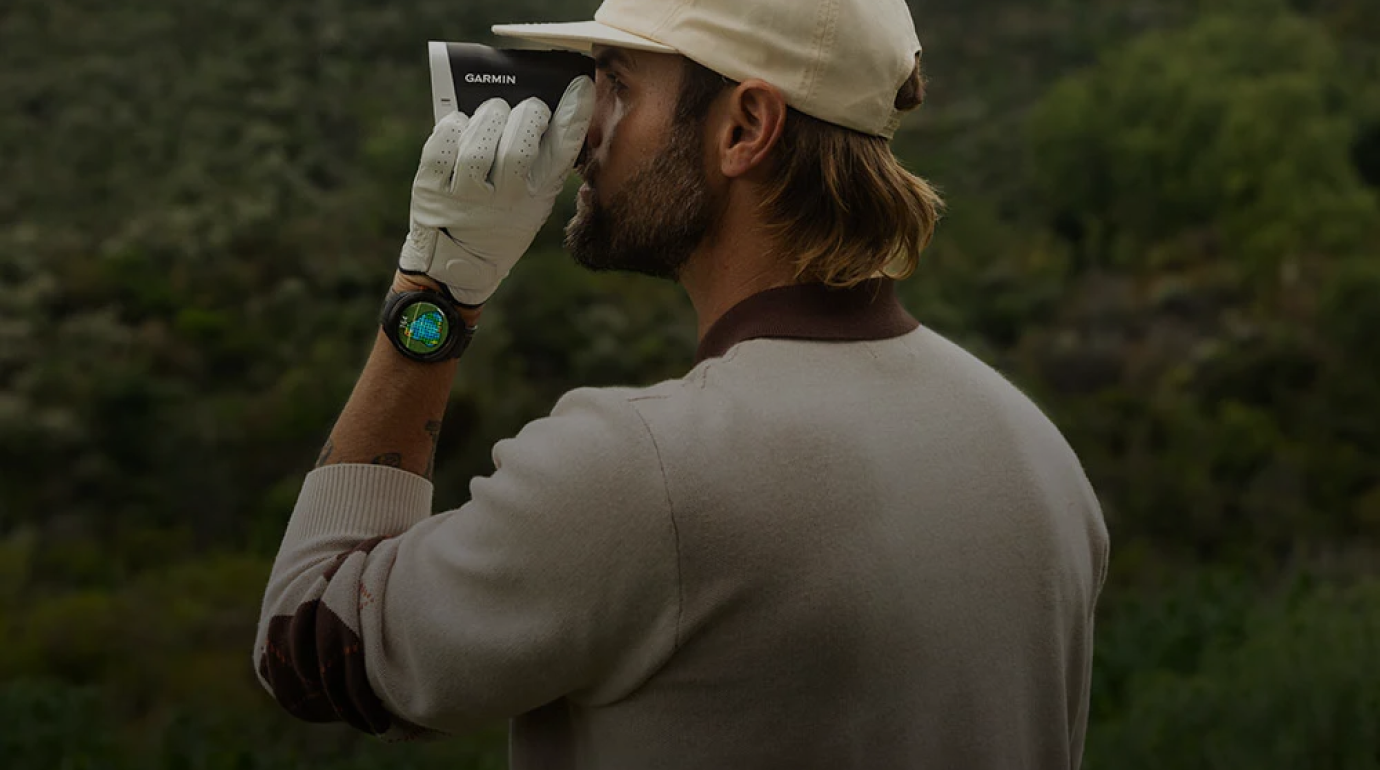 Man using a Garmin rangefinder, symbolising performance precision while playing golf.