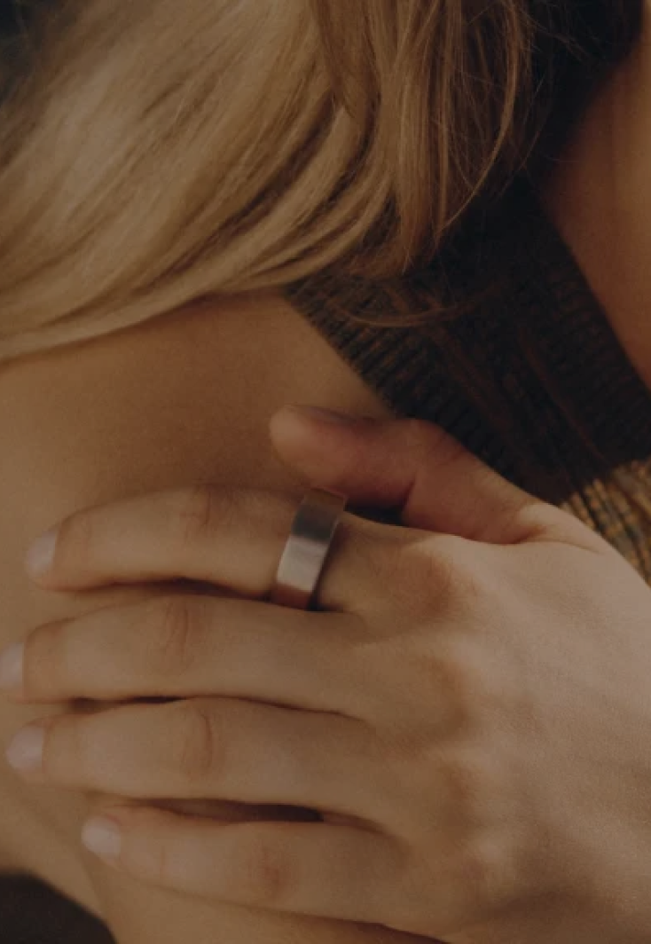 Close up of a woman with blonde hair wearing an Oura Ring.
