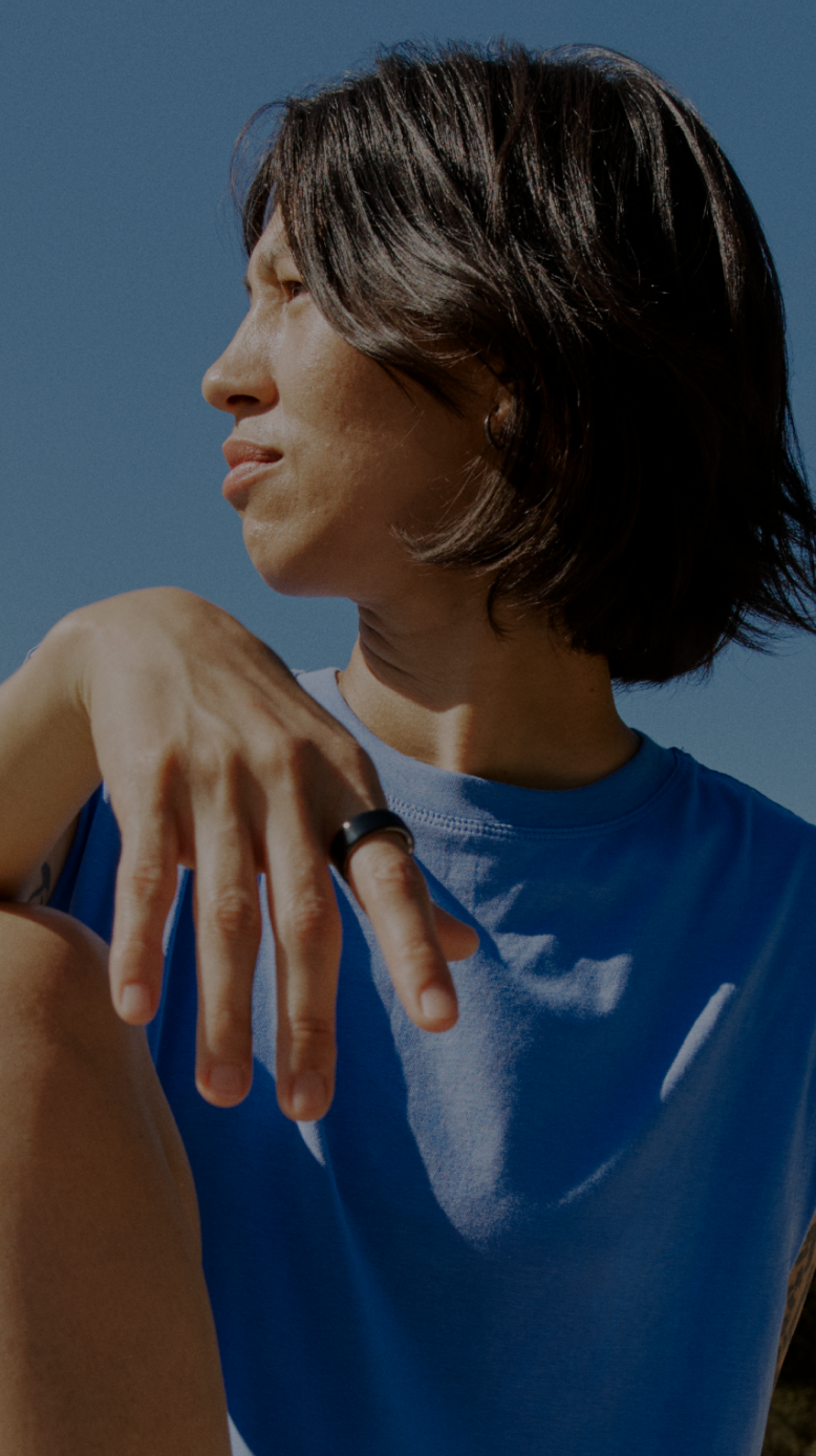 A woman wearing an Oura Ring sits in natural light, reflecting calmly. A Stella overlay shows a skin insight synced from Oura data.