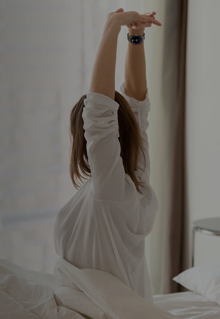 Woman stretching inside while wearing Samsung Galaxy Watch.