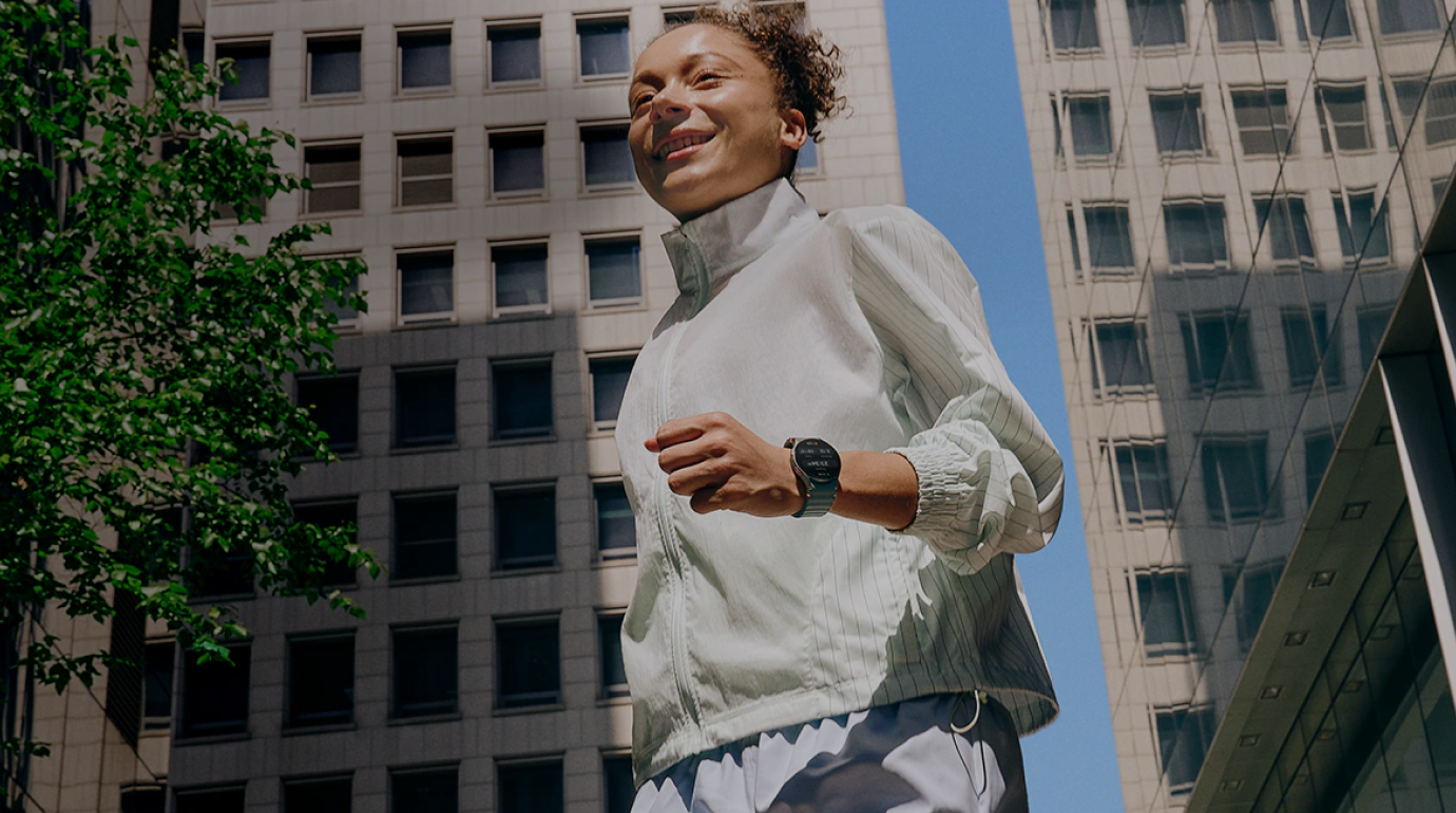 Woman wearing a Samsung Galaxy Watch smiling outdoors in a city